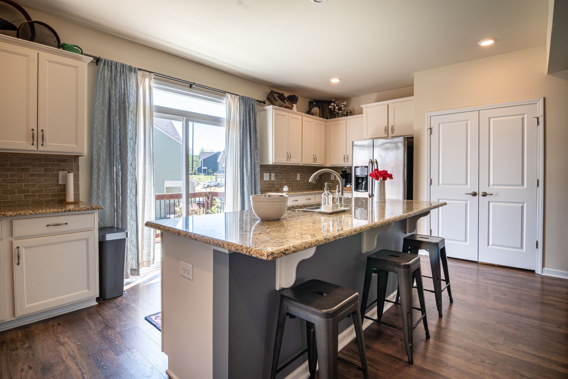 Contemporary kitchen featuring granite countertops, natural lighting, and elegant furnishings. Ideal for home in Austin, TX