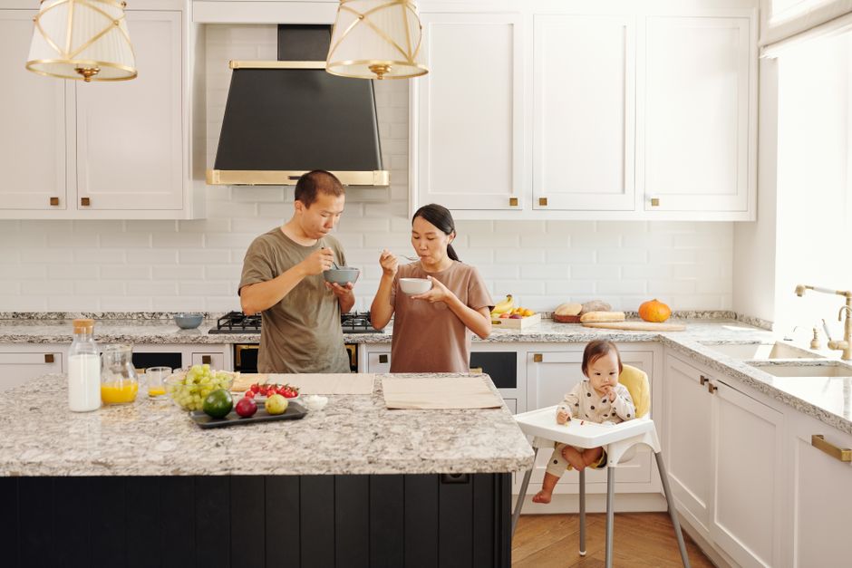 Bright kitchen with a long stone countertop and a dining area.