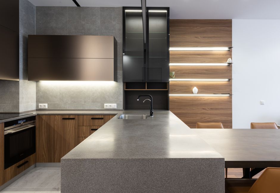 Kitchen with wooden cupboards, a stove and a gray countertop.