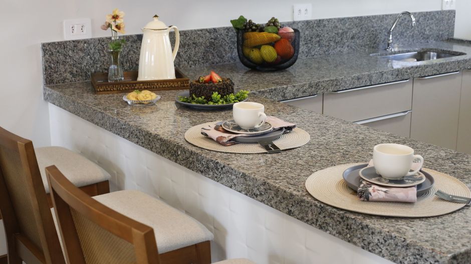 Kitchen counter with place settings on a stone countertop.